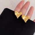Detail shot of gold heart earrings with a unique hammered texture on the surface - Gold