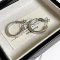 Detail view of silver hoop earrings with frosted finish texture on jewelry display - Matte Hoop Style (C208) / Silver