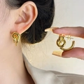Detailansicht der goldenen Doppelring-Ohrringe mit modernem geknotetem Metalldesign - Goldfarbener Gedrehter Stil (E304)