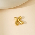 Pendentif lettre K doré poli style bulle présenté sur un fond texturé minimaliste - Lettre Bulle K Pendentif Uniquement (Sans Chaîne)