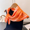 Detail of orange paisley silk scarf tied on a black sleeveless top for an elegant look - 70x70cm / Orange