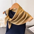 Dettaglio di un elegante foulard in seta giallo senape con motivo floreale su gruccia - 70cmx70cm / Marrone Chiaro