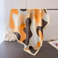 Close-up of printed silk square scarf with abstract orange waves and rolled edges - 66-70cm / Warm Orange