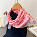 Detail of pink floral silk scarf with blue border tied on a black top on a wooden hanger - 70cm x 70cm / Pink (FG233-1)