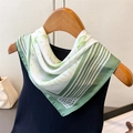 Eleganter grüner Seidenschal mit Blumenmuster, am Kleiderbügel mit Pflanzenmotiven gebunden - Grün