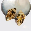 Orecchini geometrici dorati con design a pieghe irregolari su supporto bianco - Oro