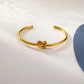 Minimalistischer goldener Knoten-Armreif mit poliertem Finish im modernen Stil - Gold