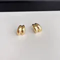 Close-up of golden teardrop wave stud earrings with a polished high-gloss metallic finish - Gold (c116)