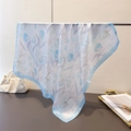 Detail of silk-like tulip print scarf draped over a stand showing smooth texture - Blue