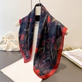 Elegant tulip print silk scarf in navy blue with red borders on a white garment - Red