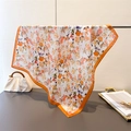 Elegant floral silk scarf with orange satin border displayed on a metal rack - Warm Orange (FG179-3) / 66-70cm
