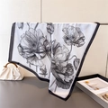 Detailed view of floral printed silk scarf with elegant black poppy flower patterns - Black