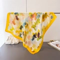 Detail of colorful abstract print silk scarf draped elegantly over a metal bar - 66-70cm / Yellow