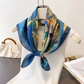 Sciarpa in seta con stampa animalier blu e gialla appesa a una gruccia bianca minimalista - Blu navy