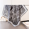 Dettaglio di un foulard setoso con stampe floreali tropicali e bordo a righe bianche e nere - Nero (FG252-1)