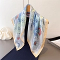 Elegant floral silk square scarf with colorful botanical print hanging on a wooden hanger - Blue
