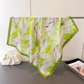Elegant silk scarf with green leaf print displayed on metal rack for premium fashion look - 66-70cm / Green