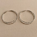 Close-up of silver double-hoop earrings with hammered texture on beige canvas background - 5cm / Silver