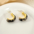 Détail macro de boucles d'oreilles en C avec métal doré et résine marbrée grise - Noir d'encre (c202)