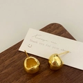 Detailed view of glossy gold irregular round earrings on a premium wooden stand - Gold Moon Earrings