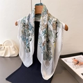 Detail of silk scarf with giraffe and tropical plant prints over a black knit dress - White