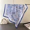 Detailed view of large satin silk scarf with blue nature prints and rolled edges - Navy Blue