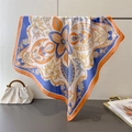 Close-up of printed faux silk square scarf draped on a metal rack with artistic patterns - Blue (FG270-3)