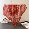Detail of red paisley silk scarf with white floral patterns draped on a metal stand - One Size / Brick Red