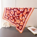Detail view of red leopard print silk scarf draped elegantly on a metal stand - Orange