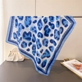 Satin silk scarf with blue leopard print and border displayed with elegant fashion accessories - Blue