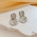 Detail of silver wavy disk earrings with textured hollow mesh on a stone stand - Silver Round Style (G219)