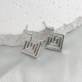 Primer plano de pendientes cuadrados plateados con diseño de remolino en piedra - Plateado