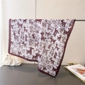 Detail of a white silk scarf with dark brown giraffe prints draped over a metal rod - Burgundy