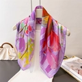 Elegant violet floral silk scarf displayed on a white dress in a lifestyle setting - Purple