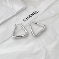 Gros plan de boucles d'oreilles triangles géométriques en métal poli au fini argenté - Argenté