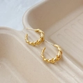 Detalle de pendientes dorados con textura de cuerda torcida y diseño minimalista en forma de C - Dorado