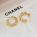 Orecchini a cerchio dorati a forma di doppia C con trama vintage a corona raffinata - Oro
