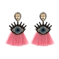 Detail view of evil eye earrings featuring blue crystal inlay and vibrant pink tassels - Pink