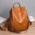 Macro view of brown crocodile-textured faux leather with anti-theft zipper detail - Brown