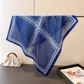 Detail of blue and white polka dot silk scarf hanging with premium texture and drape - Navy Blue