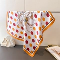 Detailed shot of floral polka dot silk scarf draped with smooth texture and orange border - 66-70cm / Orange (FG329-1)