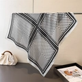 Close-up of black and white polka dot silk scarf hanging on a minimalist metal rack - White