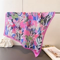 Detailed close-up of Bohemian floral silk scarf with pink rolled edges and vibrant patterns - Pink