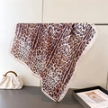 Detailed view of leopard print silk scarf with elegant pink edges on metal rack - Off White