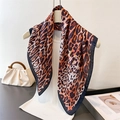 Leopard print satin square scarf with dark borders draped on a white top - Black Trim