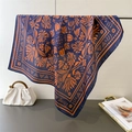 Detailed view of floral printed silk square scarf in navy blue and orange draped on a stand - Navy Blue