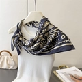 Close-up of floral print silk scarf in navy blue knotted on a white tank top - Black