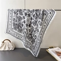 Close-up of floral print silk scarf draping elegantly over a metallic horizontal bar - White