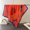 Detail of silk scarf with orange chain print and blue borders on a display stand - 66-70CM / Orange
