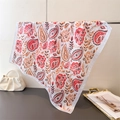 Detailed close-up of paisley silk scarf draped over a metal bar with elegant handbag - 66-70cm / Orange Red